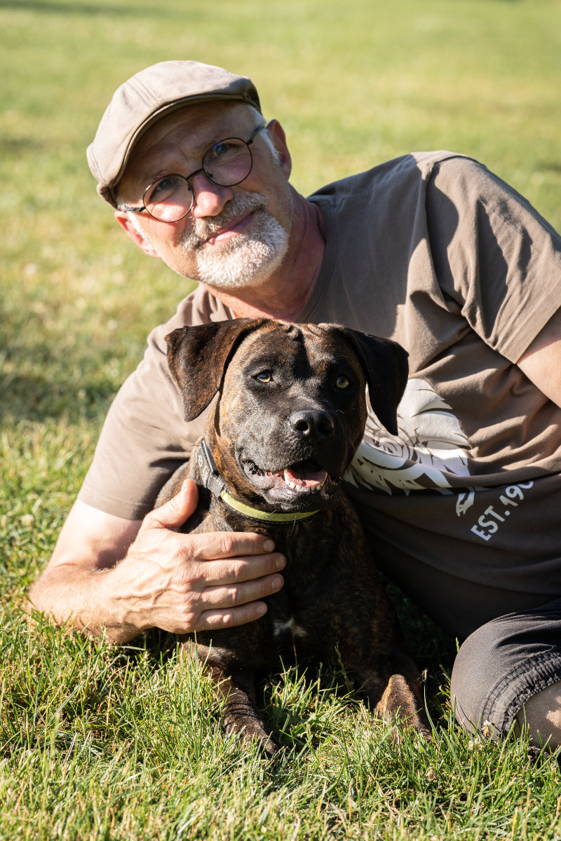 Ein Teilnehmer zeigt die enge und vertrauensvolle Beziehung zu seinem Hund nach dem Training.